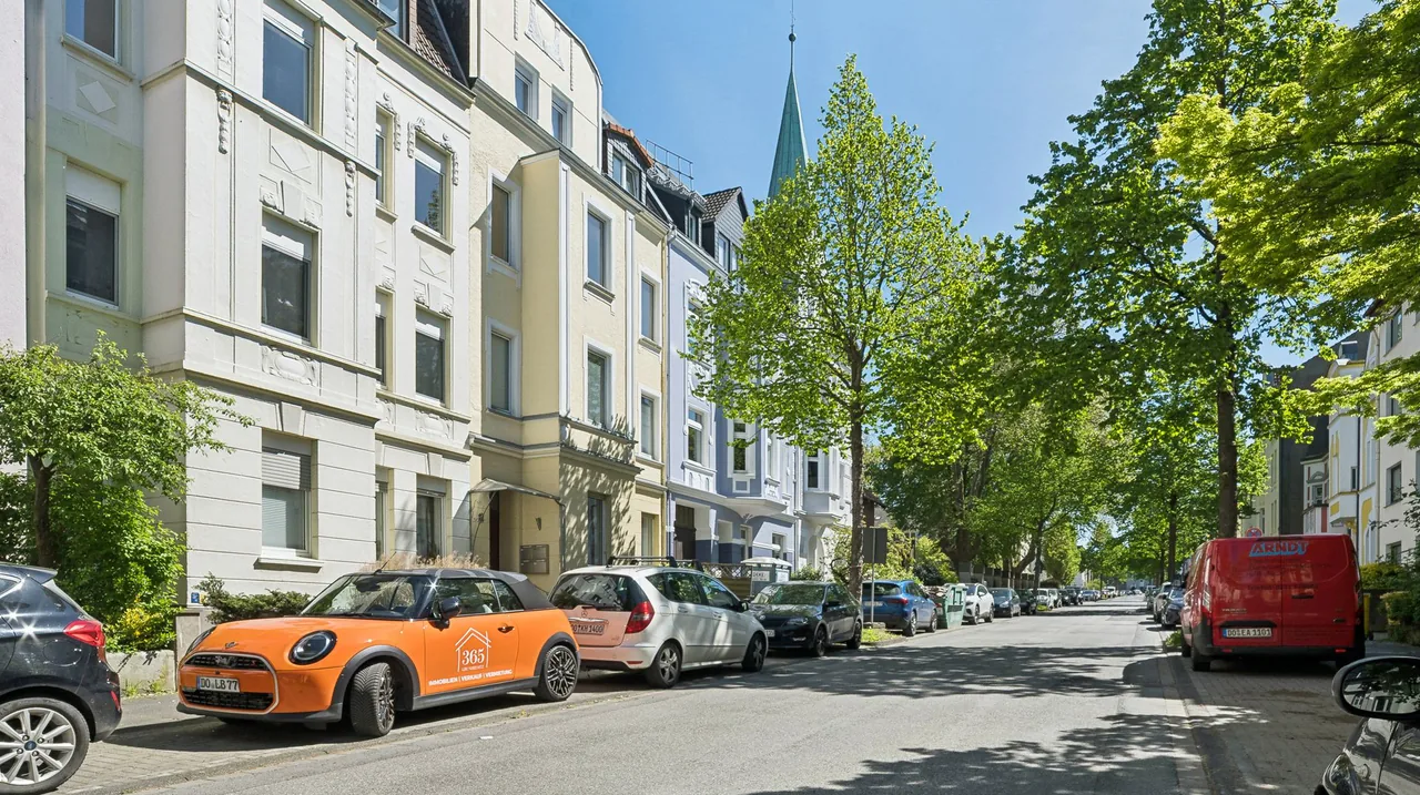 Der orange 365-Grundbesitz-Wagen parkt in einer Dortmunder Altbaustraße mit Gründerzeithäusern